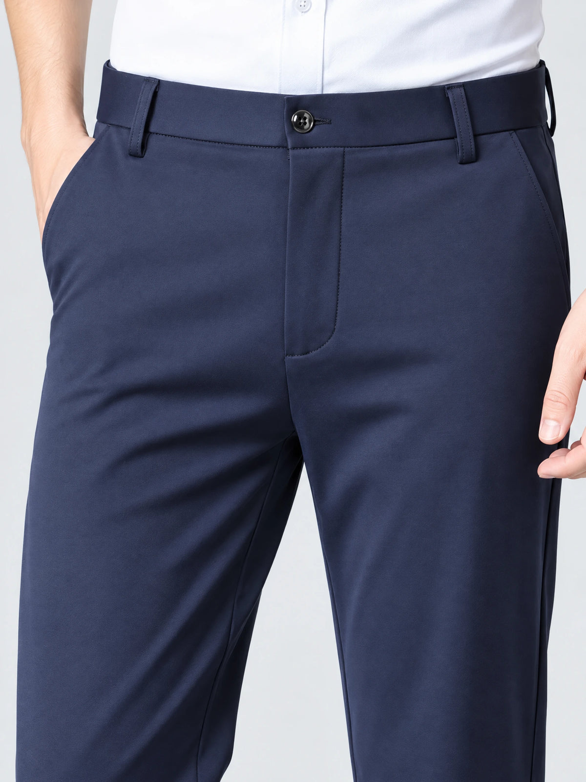 Close-up of Navy men's pants showing the button waistband, belt loops, fly, and side pockets.