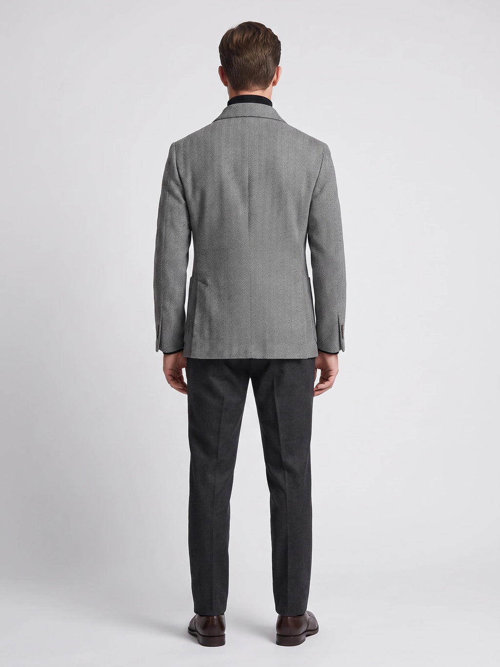 Rear studio view of a model wearing a Gray wool Men Suit Coat with a herringbone pattern.