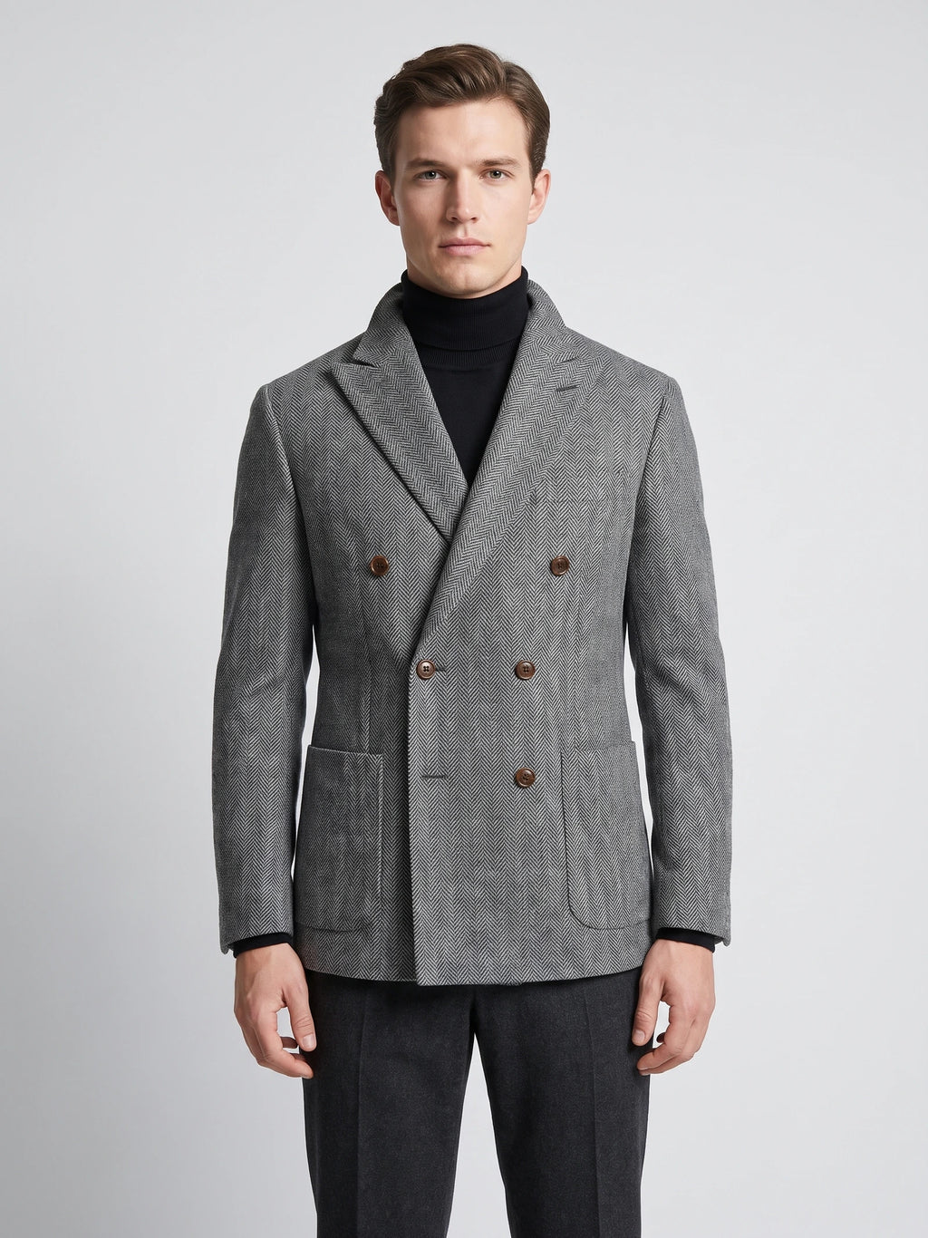 Front studio view of a model wearing a Gray Men Suit Coat with herringbone wool texture, peaked lapels, flap pockets, and double-breasted buttons.