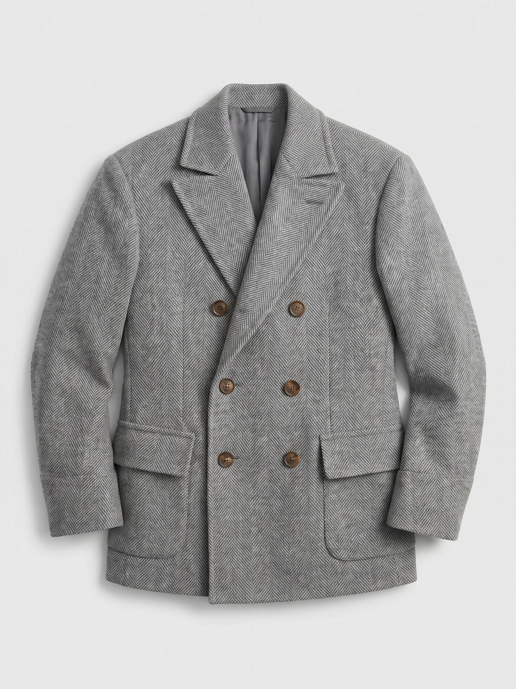 Gray wool men’s suit coat laid flat, featuring a herringbone weave, peak lapels, flap pockets, and six-button double-breasted front.