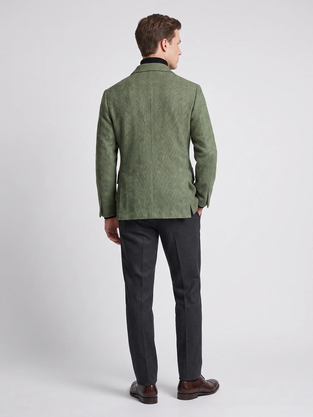 Rear studio view of a model wearing a Green wool Men Suit Coat with a herringbone pattern.