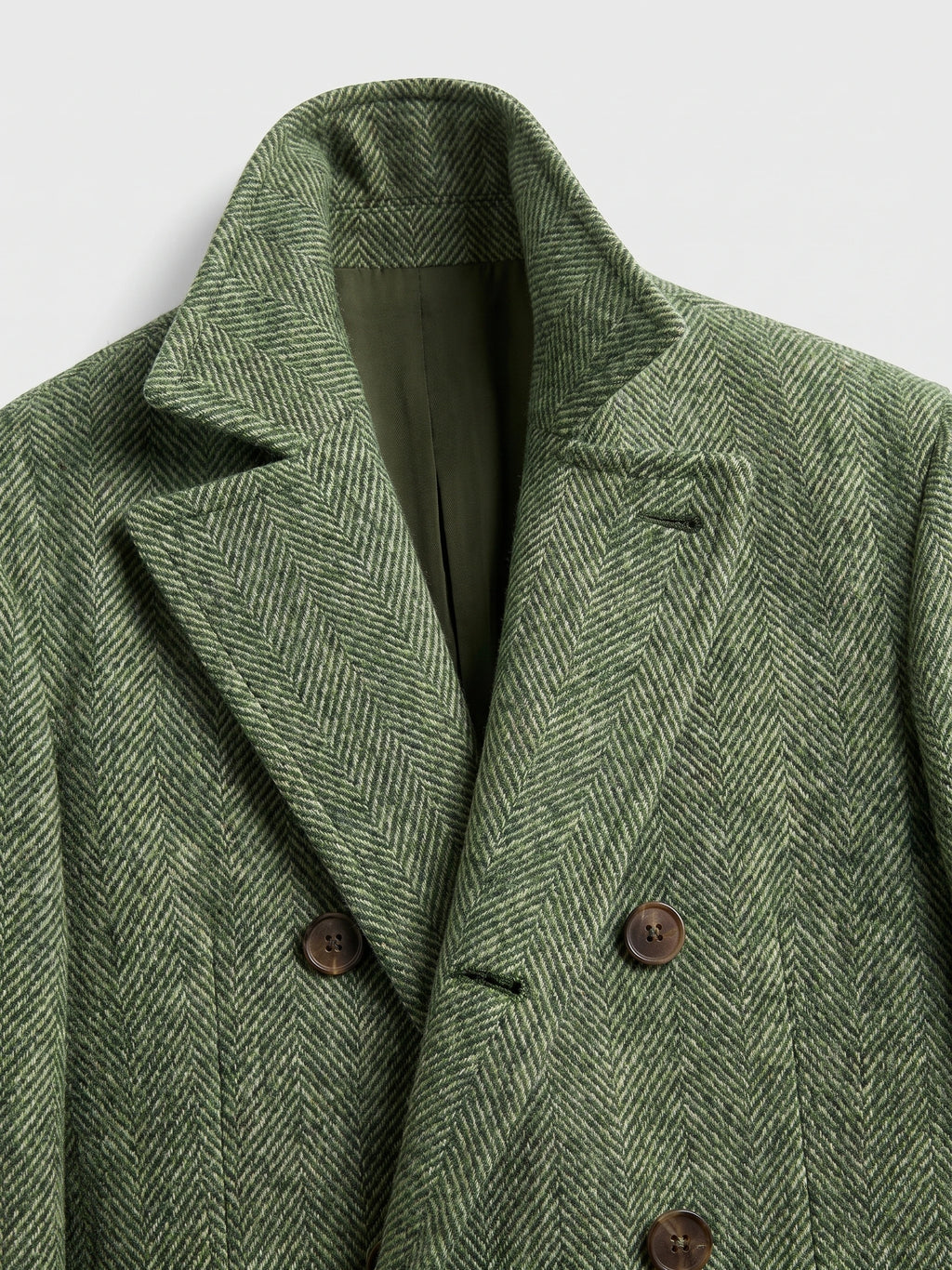 Close-up of a Green Men Suit Coat in wool herringbone, showing the notched lapel, lining, and double-breasted buttons.