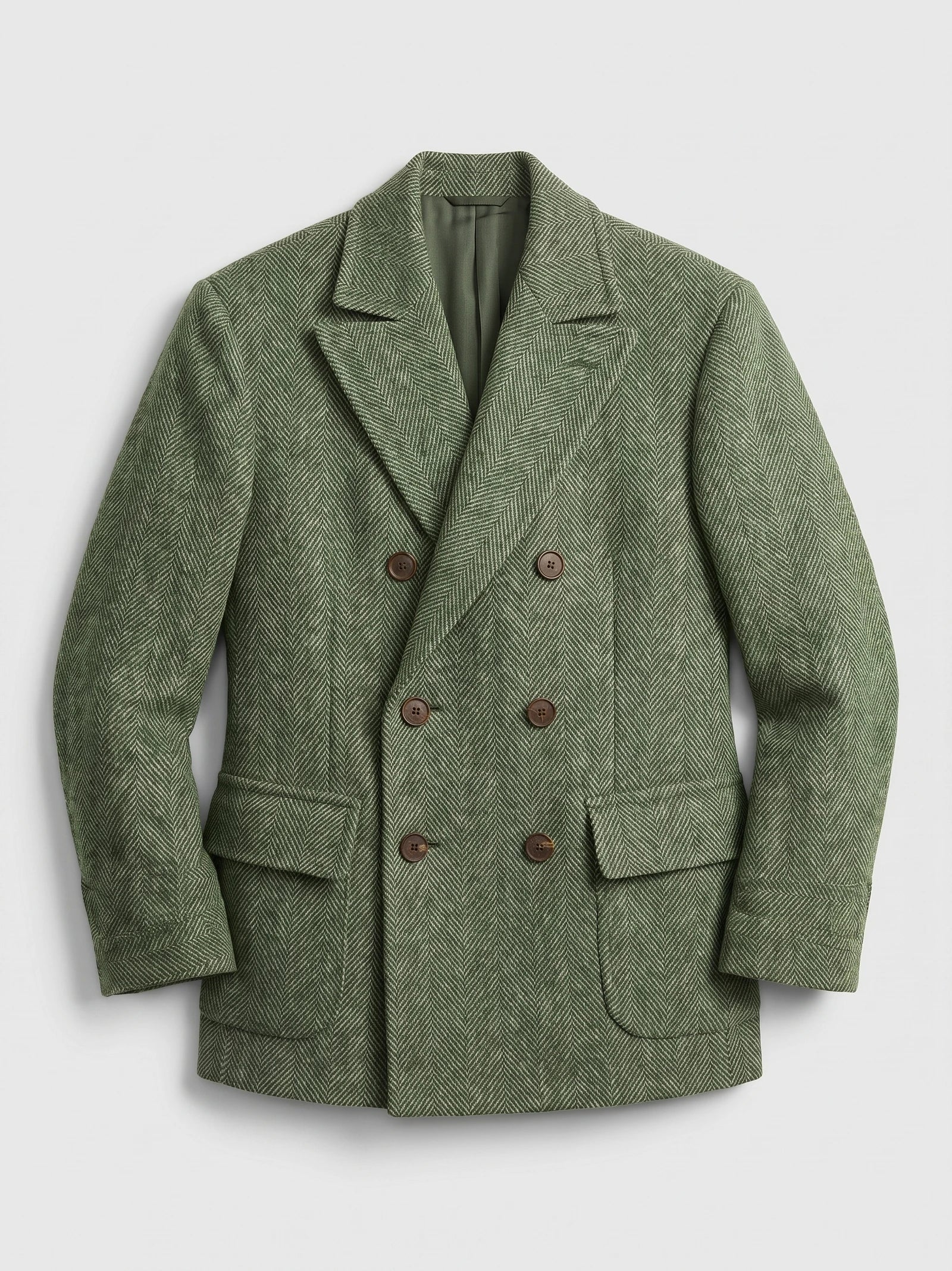 Green Men Suit Coat laid flat, featuring a herringbone weave, peaked lapels, flap pockets, and double-breasted buttons.