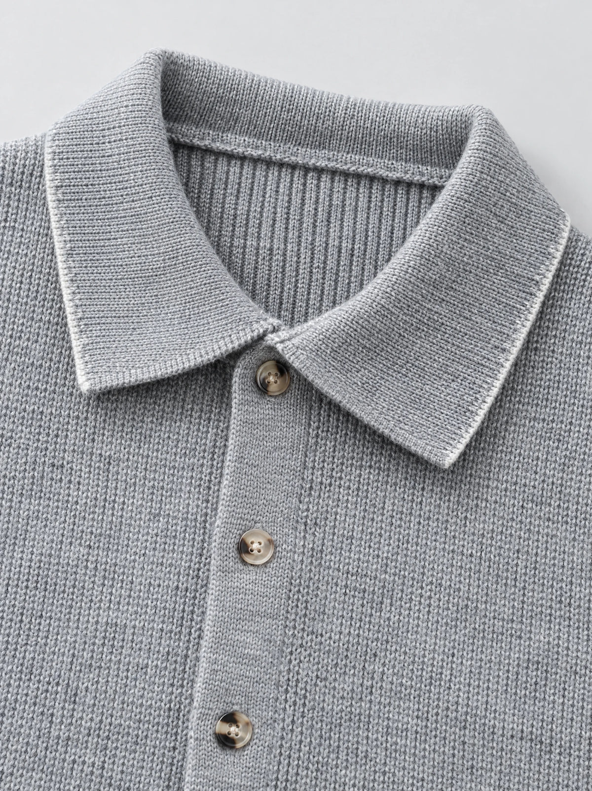Close-up of the Gray cotton Sweater Vest showing its ribbed lapel collar, knit texture, and button-front placket.