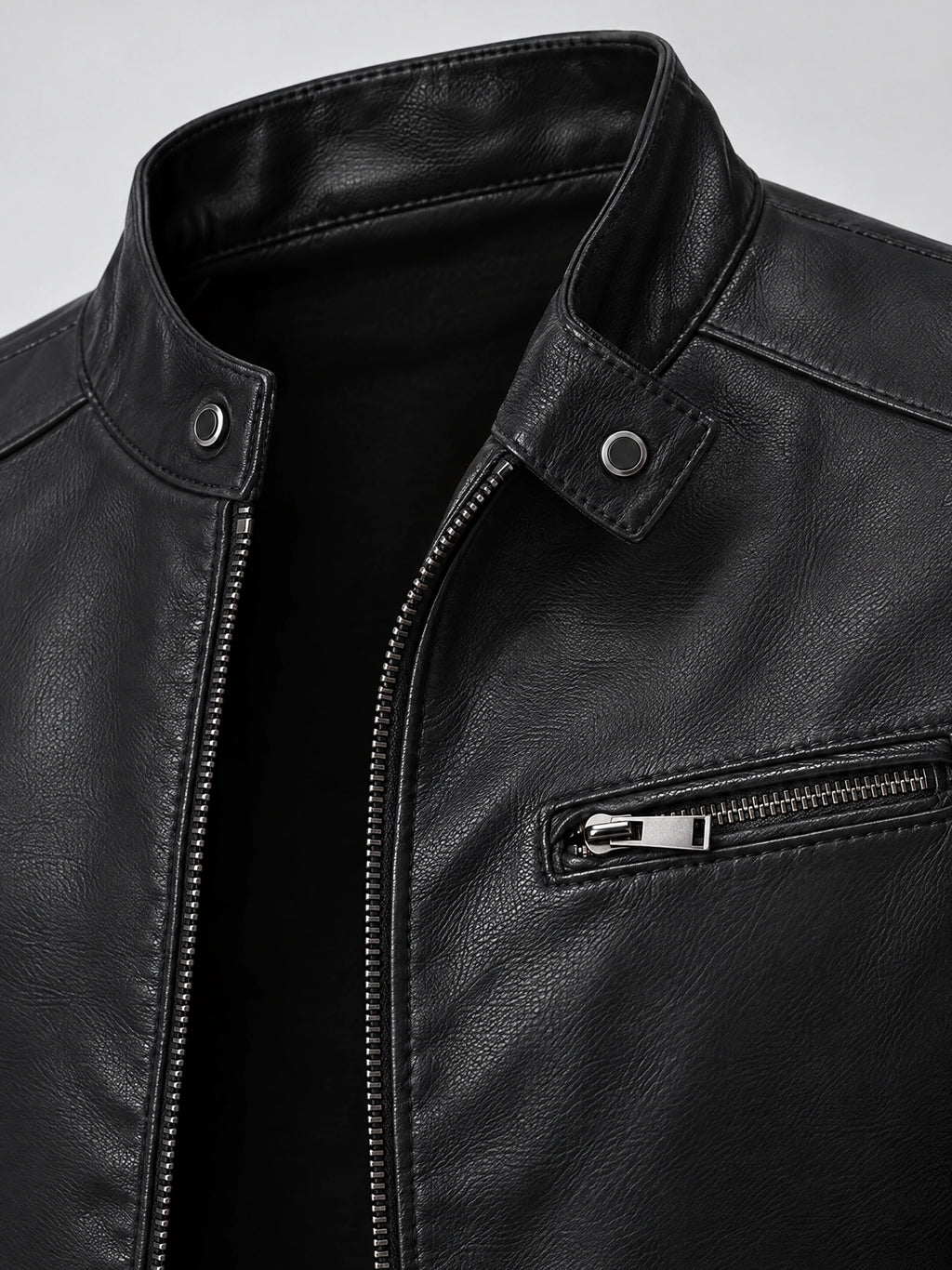 Close-up of the Black tailored leather jacket’s snap-tab collar, front zipper, and zippered chest pocket.