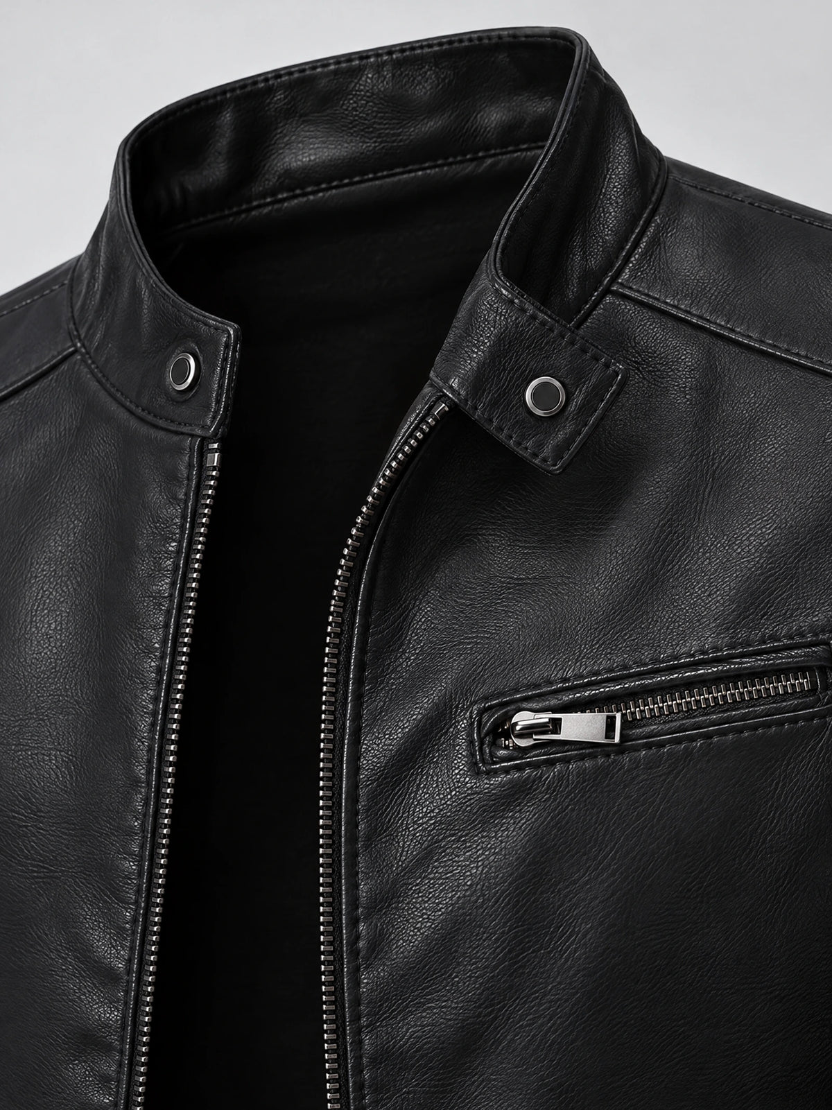 Close-up of the Black tailored leather jacket’s snap-tab collar, front zipper, and zippered chest pocket.