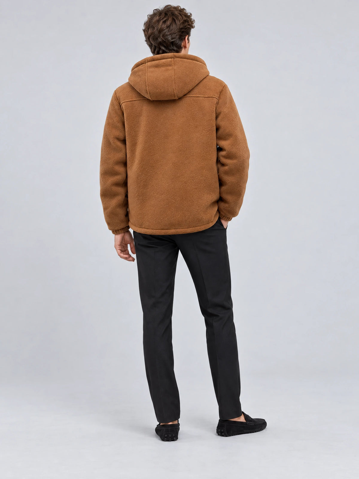Rear studio view of a model wearing a Brown teddy jacket with a hood and textured finish.