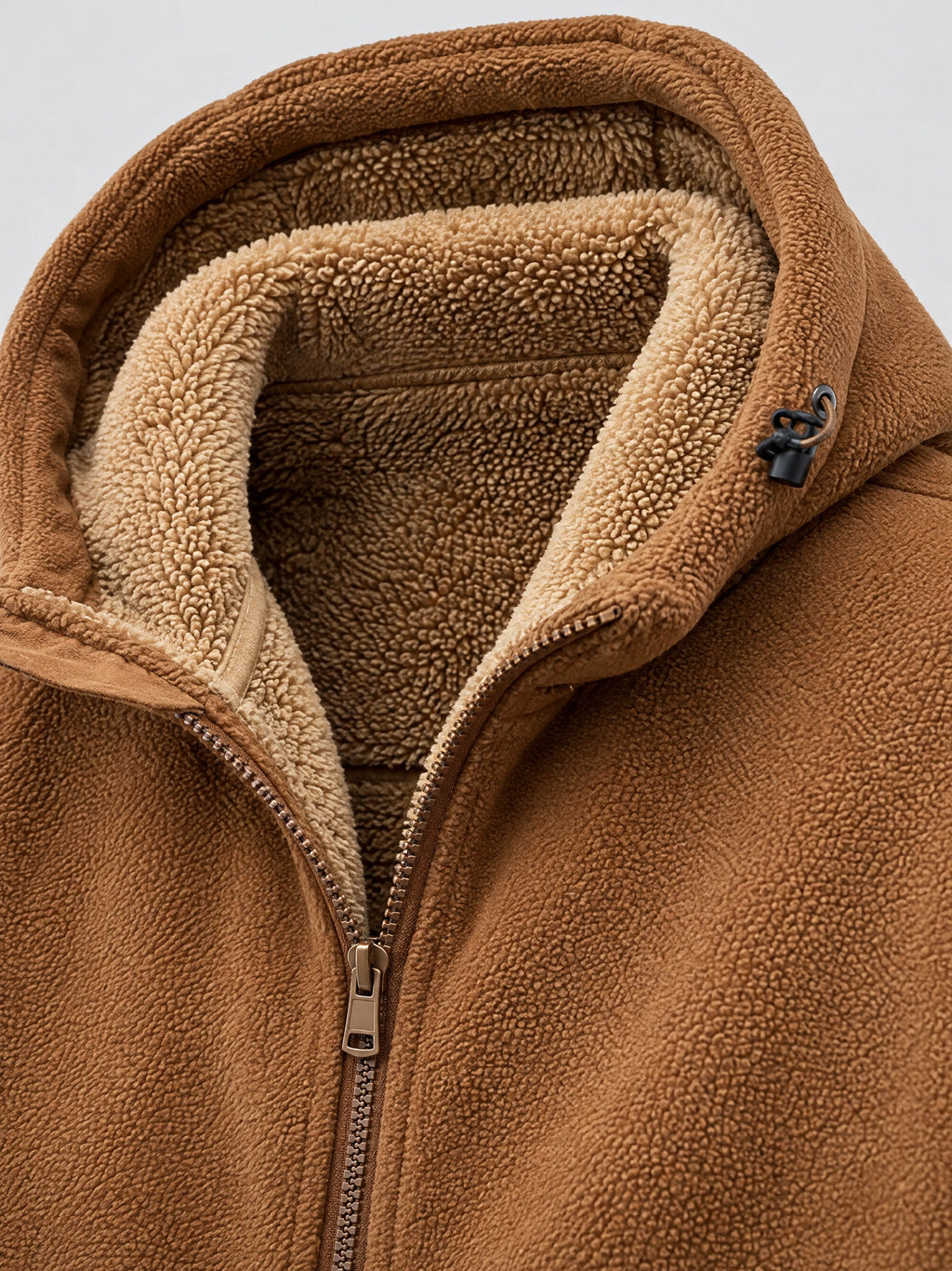 Close-up of the Brown men's Teddy jacket showing its plush lining, zip-front closure, and hood drawcord.