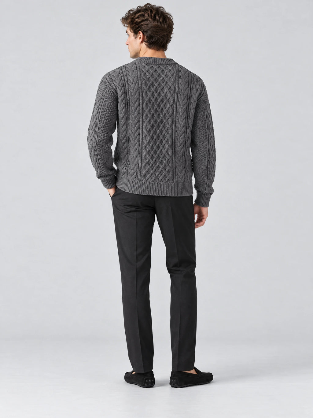Rear studio view of a model wearing a Charcoal thick sweater with cable-knit texture and ribbed trim.