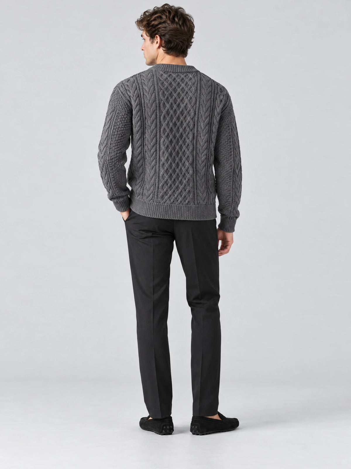 Rear studio view of a model wearing a Charcoal thick sweater with cable-knit texture and ribbed trim.