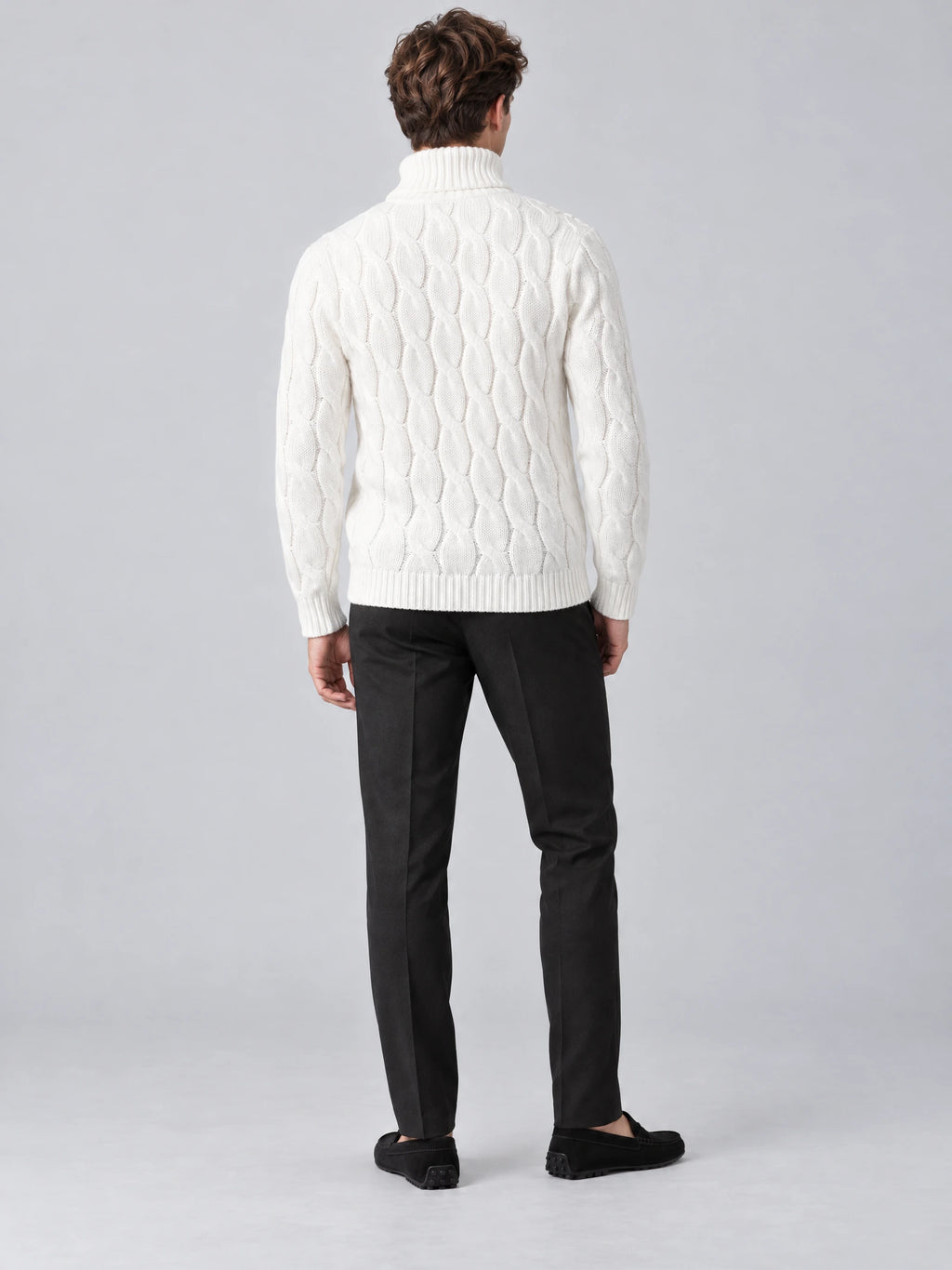 Rear studio view of a model wearing a White cotton Turtle Neck Sweater with cable-knit texture and ribbed collar, cuffs, and hem.