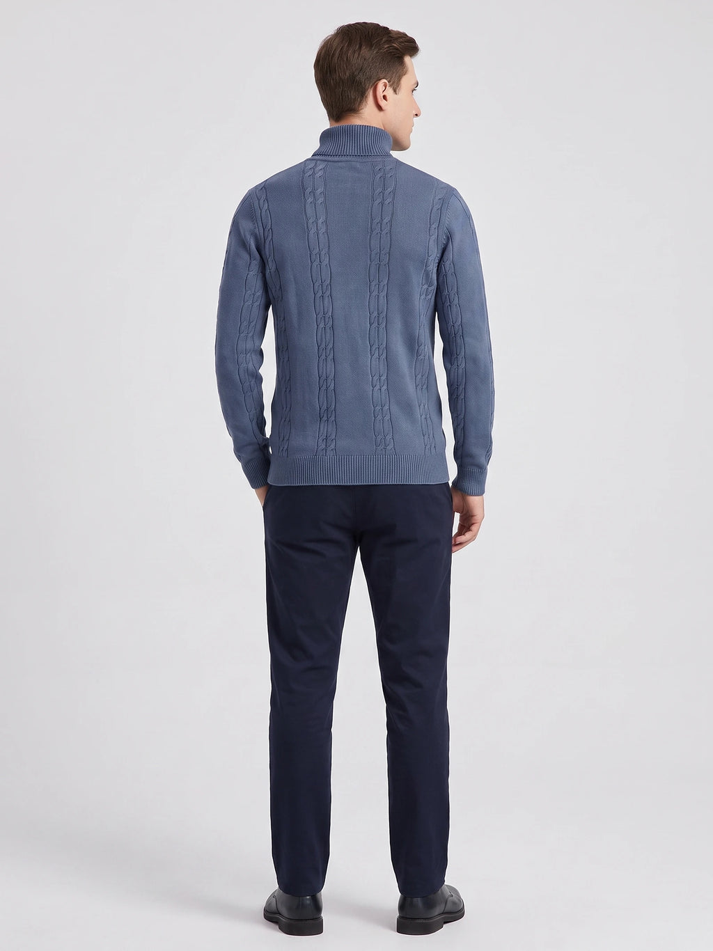 Rear studio view of a model wearing a Blue cotton Turtleneck Sweater with vertical cable-knit panels and ribbed trim.