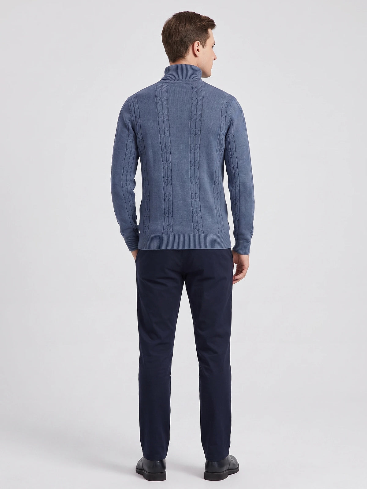 Rear studio view of a model wearing a Blue cotton Turtleneck Sweater with vertical cable-knit panels and ribbed trim.