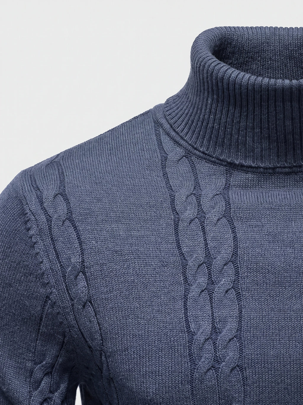 Close-up of the Blue cotton Turtleneck Sweater showing its ribbed high collar, cable-knit panels, and shoulder stitching.