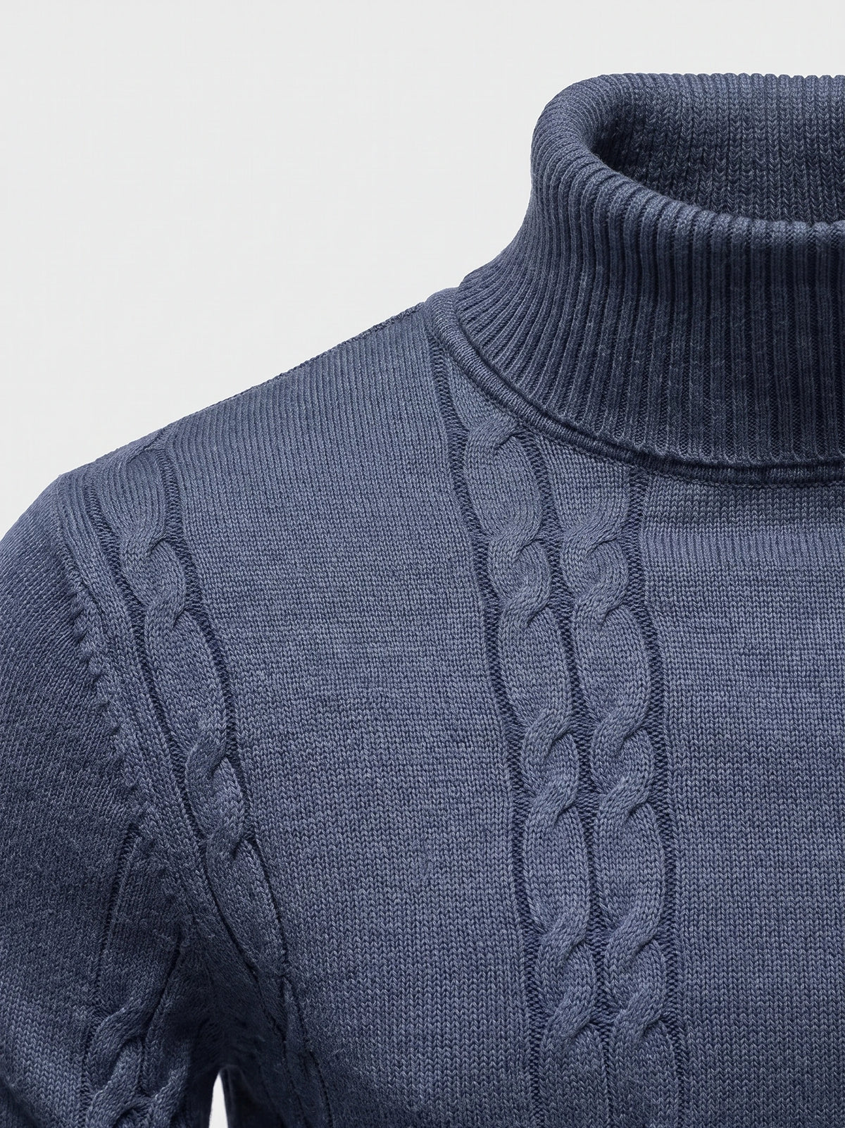 Close-up of the Blue cotton Turtleneck Sweater showing its ribbed high collar, cable-knit panels, and shoulder stitching.
