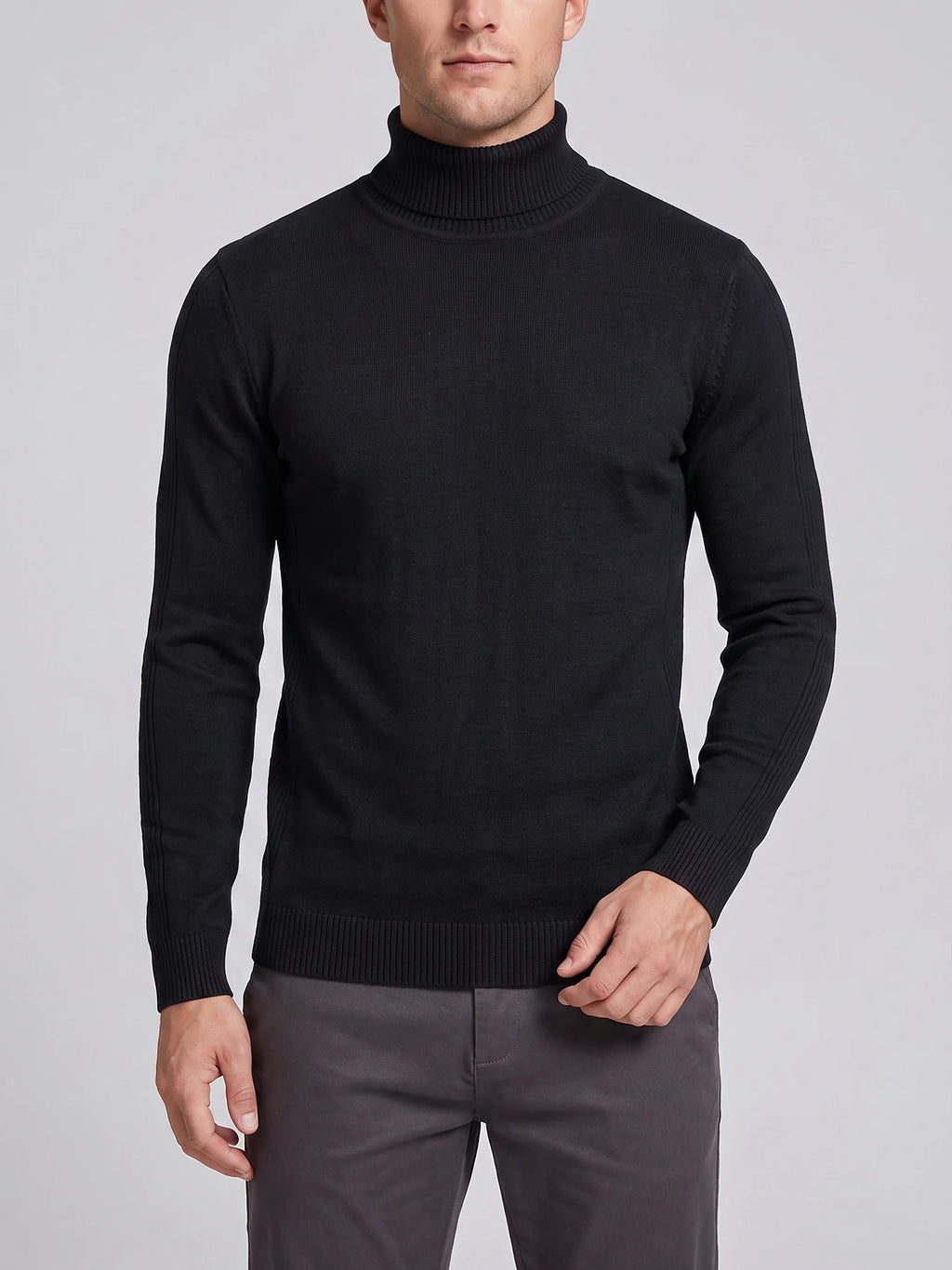 Front studio view of a model wearing a Black slim-fit Turtleneck Sweater with long sleeves and ribbed collar, cuffs, and hem.