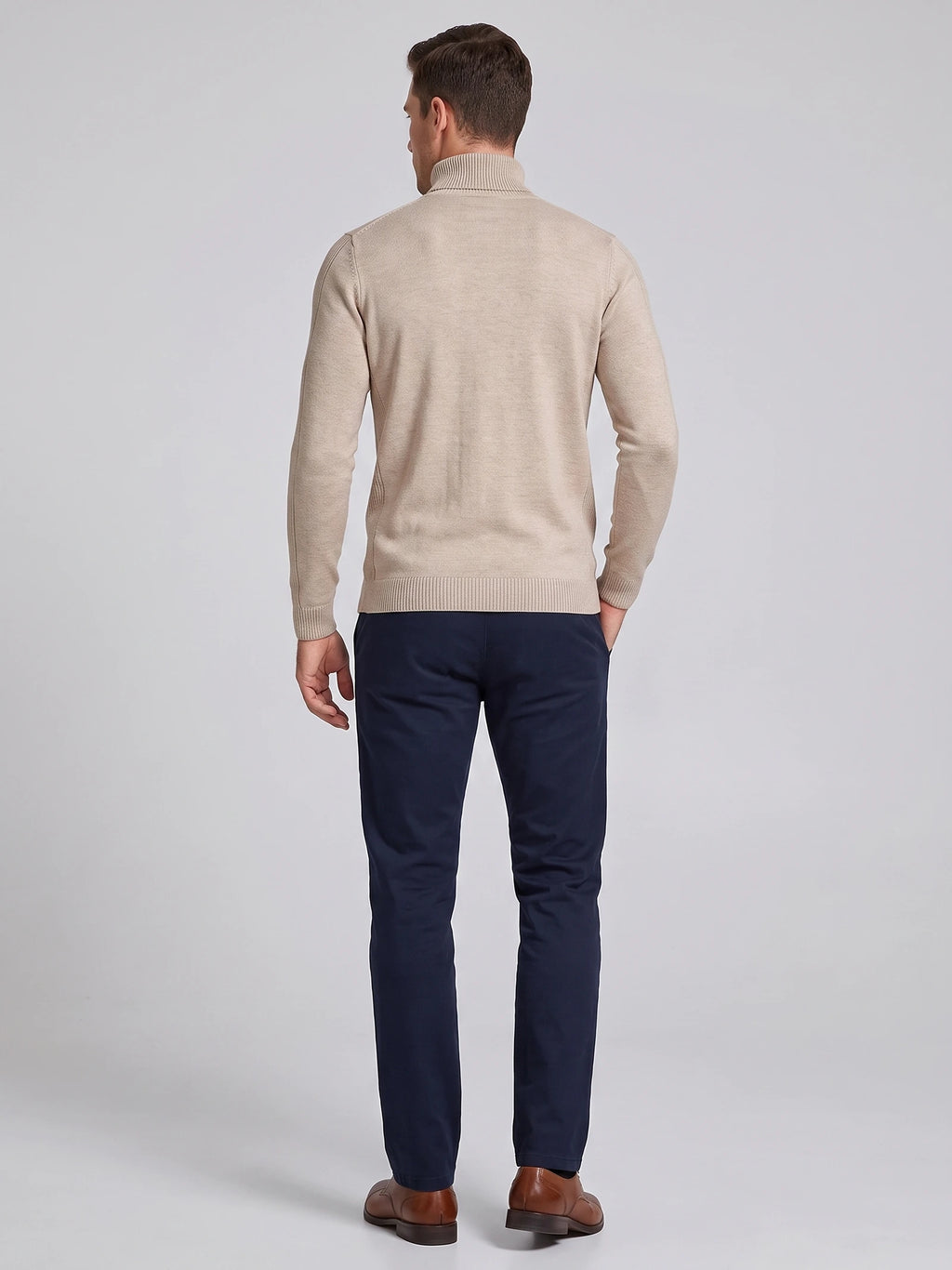 Rear studio view of a model wearing a Khaki men's Turtleneck Sweater with a ribbed high neck, cuffs, and hem.