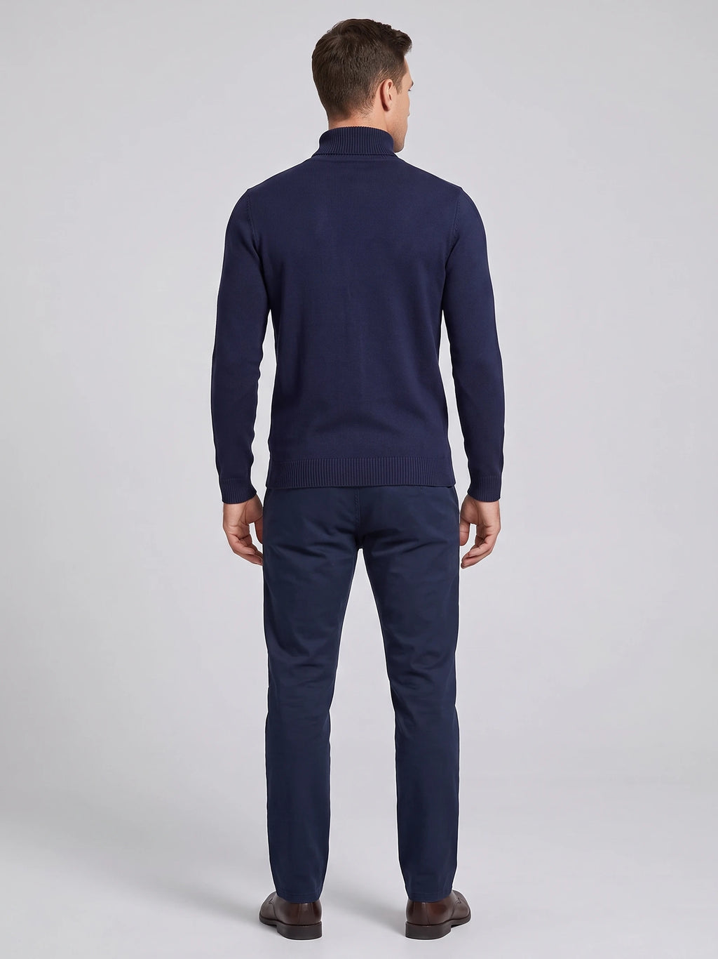 Rear studio view of a model wearing a Navy turtleneck sweater with long sleeves and ribbed cuffs and hem.