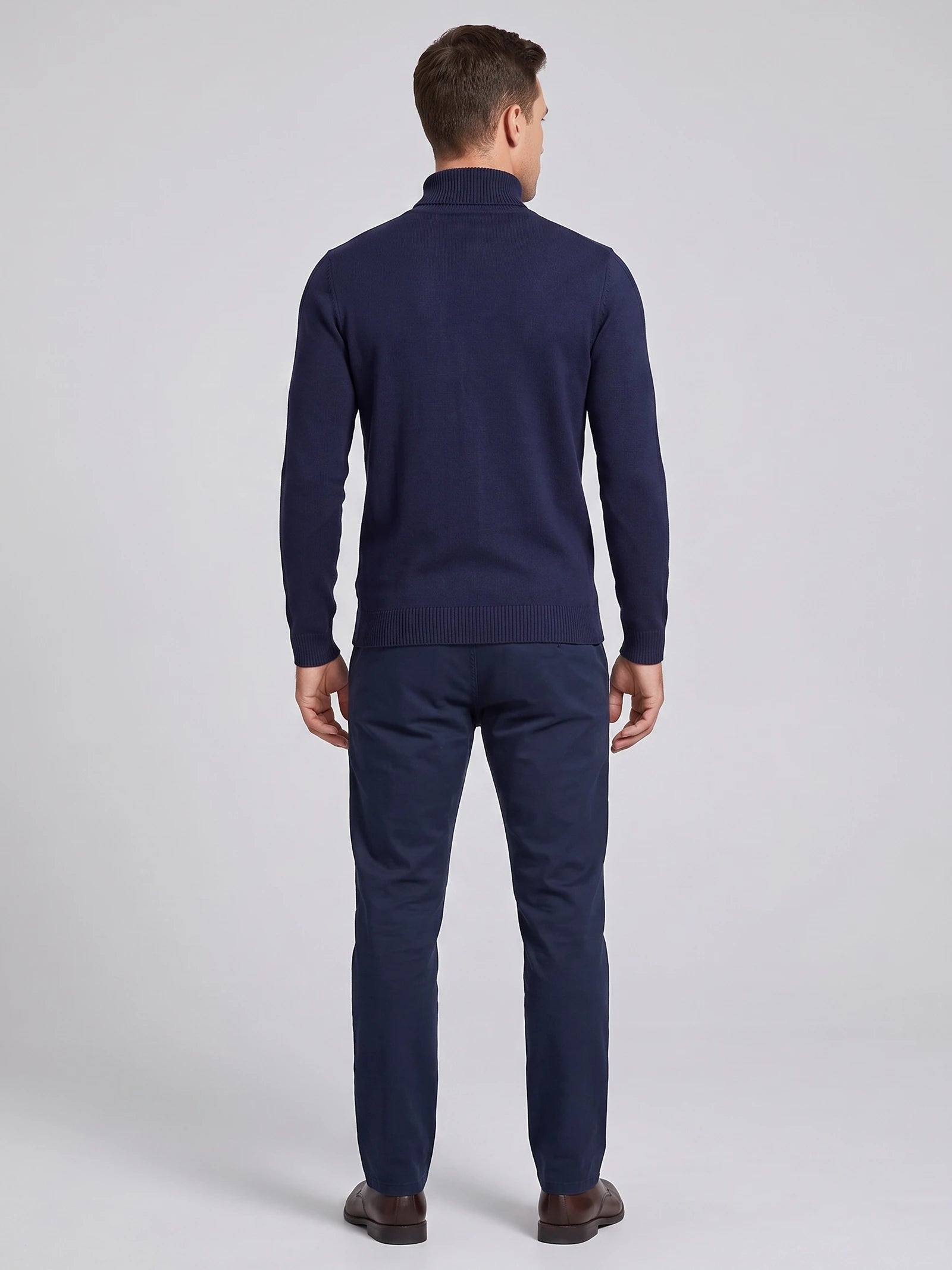 Rear studio view of a model wearing a Navy turtleneck sweater with long sleeves and ribbed cuffs and hem.