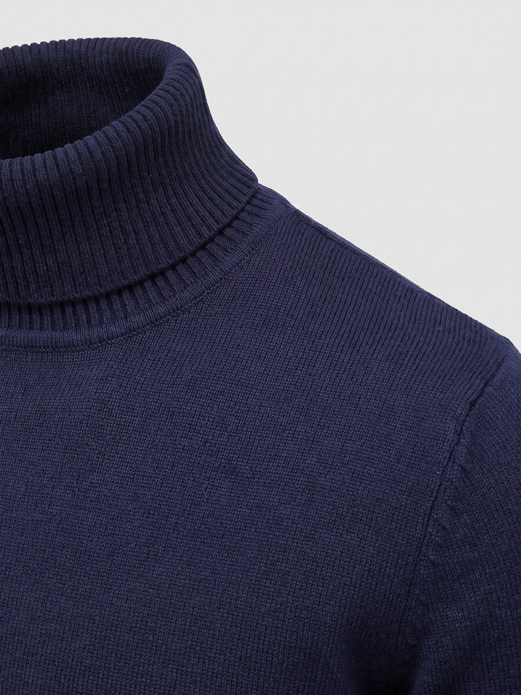 Close-up of the Navy Turtleneck Sweater showing its ribbed high neck, fine knit texture, and shoulder seam.