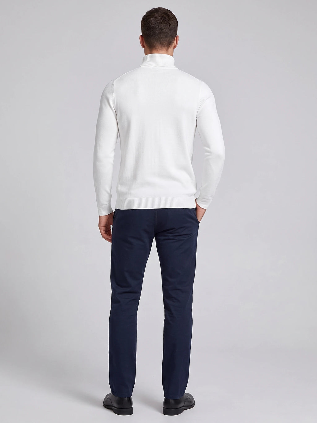 Rear studio view of a model wearing a White men's Turtleneck Sweater with ribbed collar, cuffs, and hem.