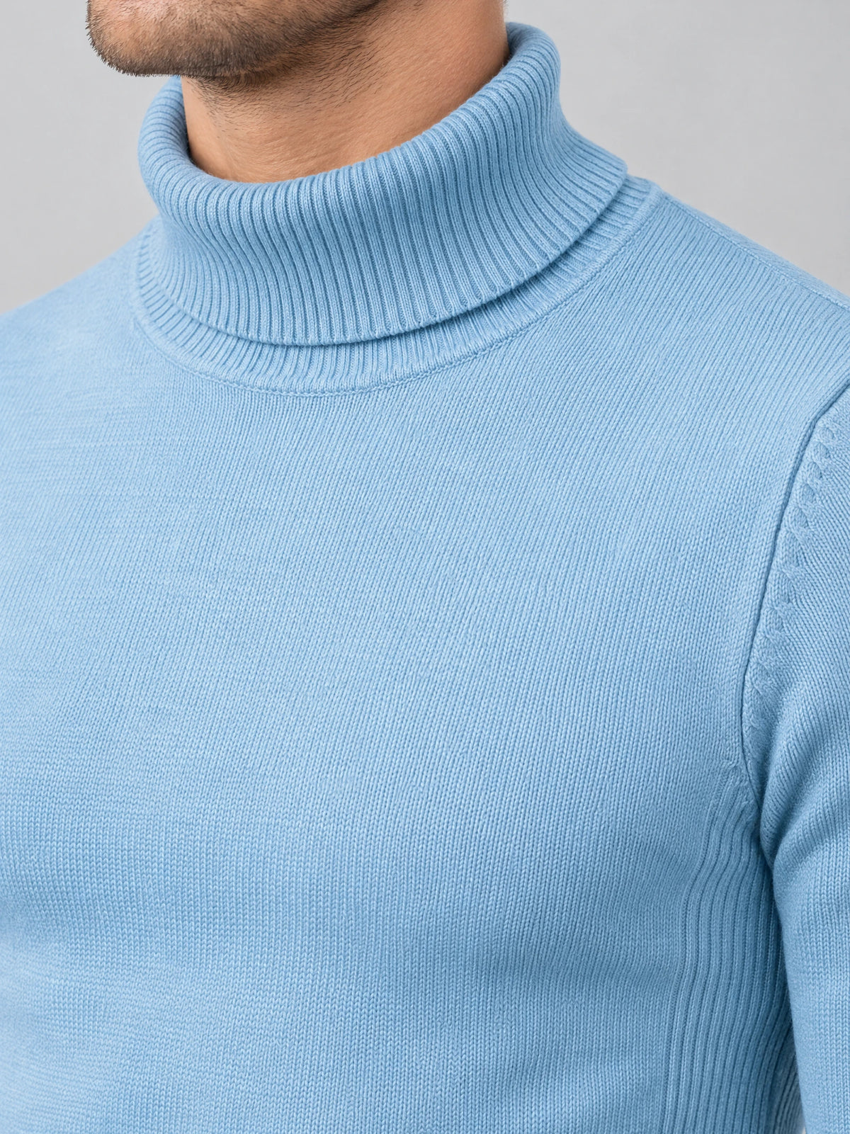 Close-up of a Light Blue men's Turtleneck Sweater showing the ribbed fold-over collar and fine knit texture.