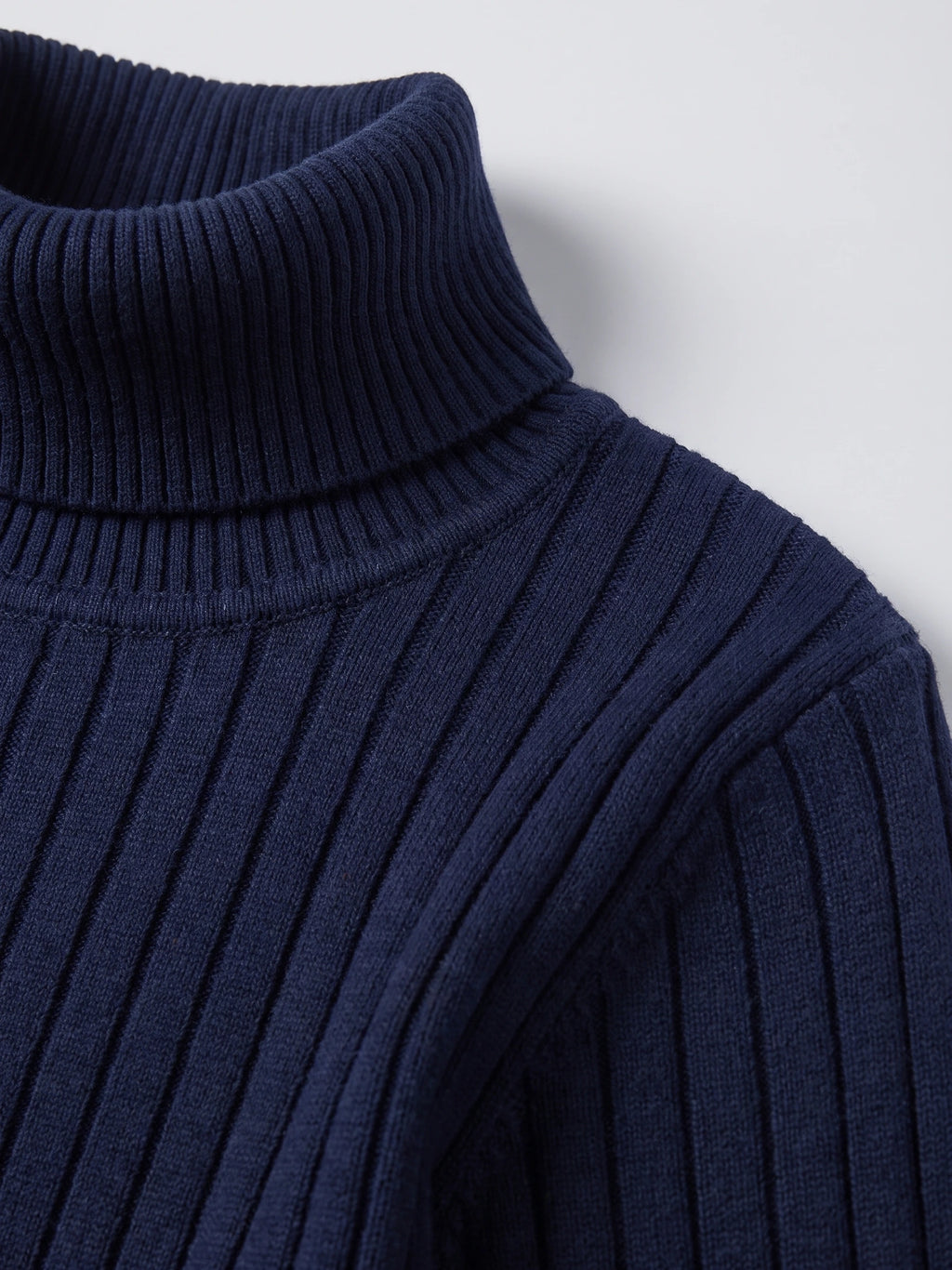 Close-up of the Navy men's Turtleneck Sweater showing its ribbed knit collar and textured shoulder stitching.