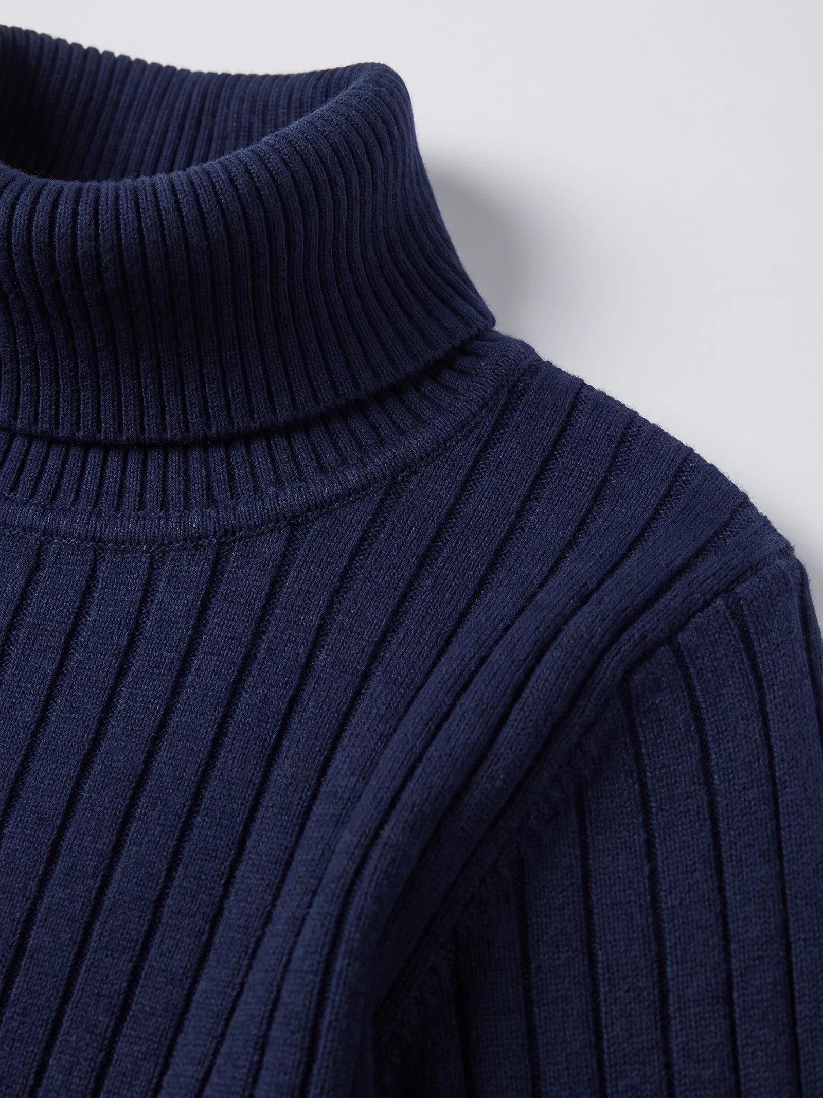Close-up of the Navy men's Turtleneck Sweater showing its ribbed knit collar and textured shoulder stitching.