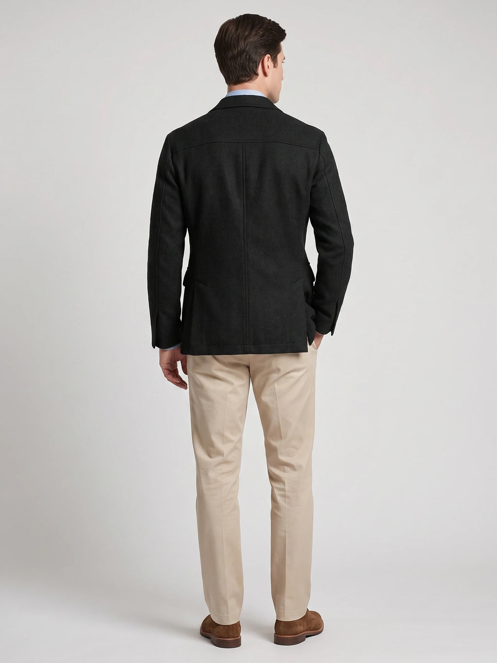 Rear studio view of a model wearing a Black Tweed Jacket with a tailored back seam and side vents.