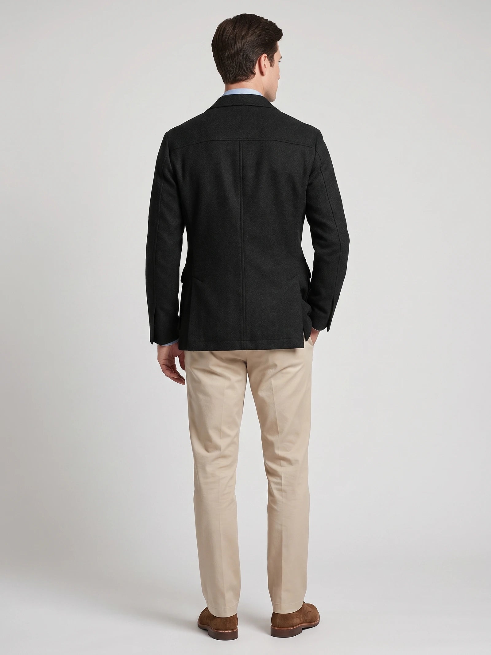 Rear studio view of a model wearing a Black Tweed Jacket with a tailored back seam and side vents.