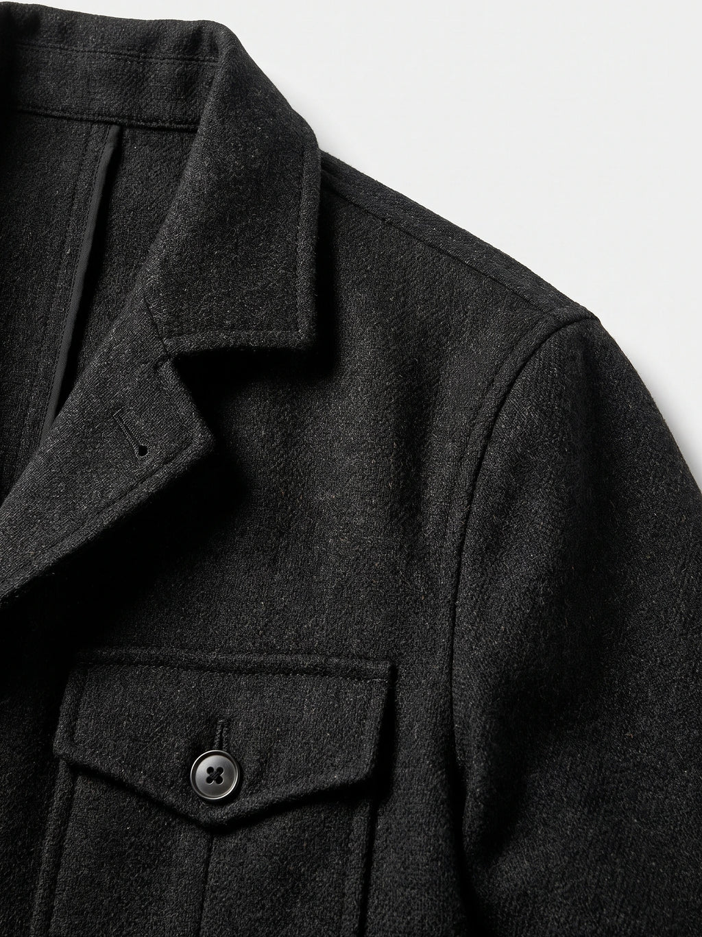 Close-up of the Black men's Tweed Jacket showing its notched lapel, textured fabric, shoulder seam, and single-breasted button.