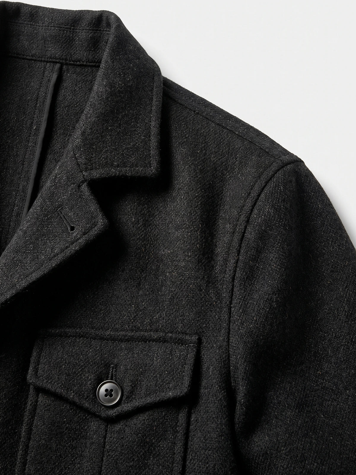 Close-up of the Black men's Tweed Jacket showing its notched lapel, textured fabric, shoulder seam, and single-breasted button.