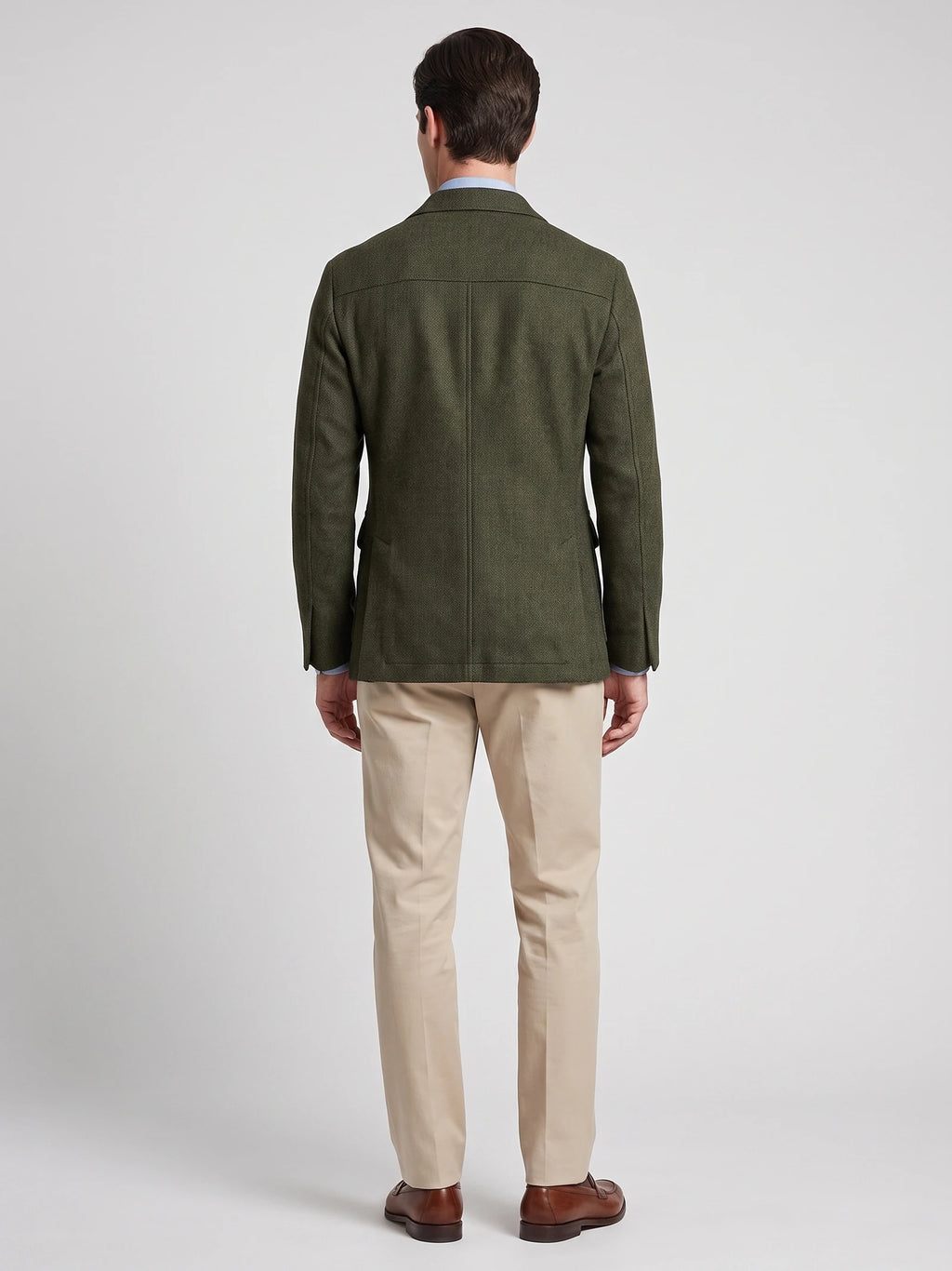 Rear studio view of a model wearing a Green tweed jacket, showing the tailored back seams and center vent.