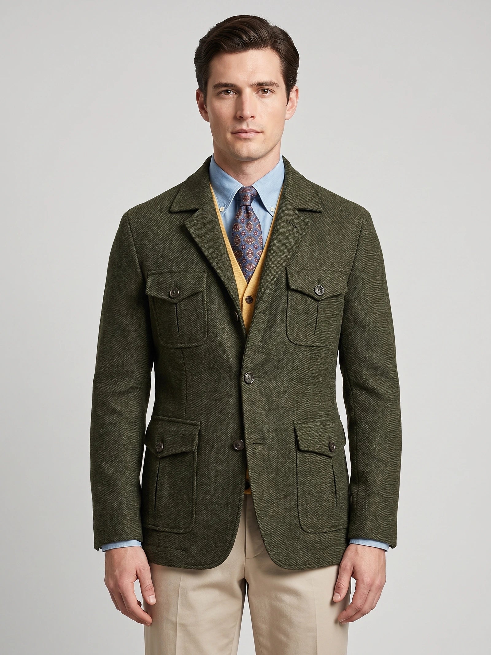 Front studio view of a model wearing a Green tweed jacket with notched lapels, button closure, and four flap pockets.