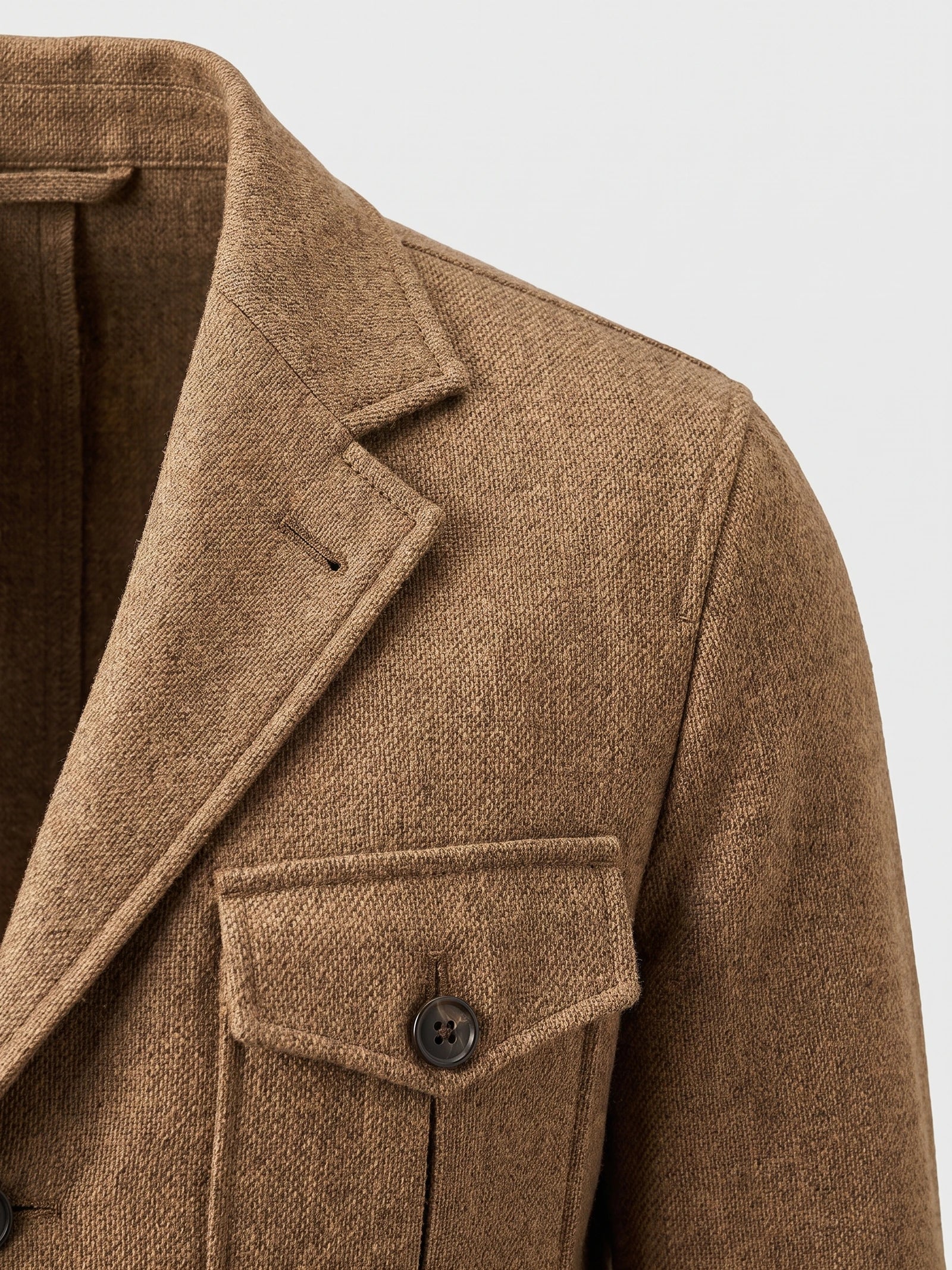 Close-up of the Khaki men's Tweed Jacket showing its notched lapel, textured weave, flap pocket, and front button.