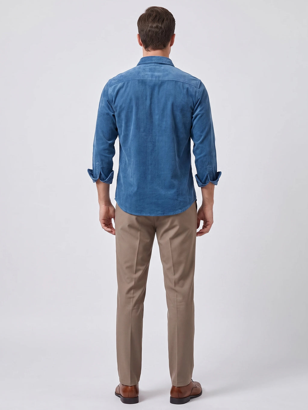 Rear studio view of a model wearing a Blue Twill Tweed Shirt with rolled sleeves and a curved hem.