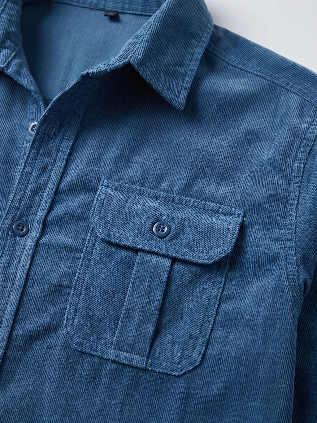 Close-up of the Blue Twill Tweed Shirt showing its ribbed cotton texture, pointed collar, button placket, and flap chest pocket.
