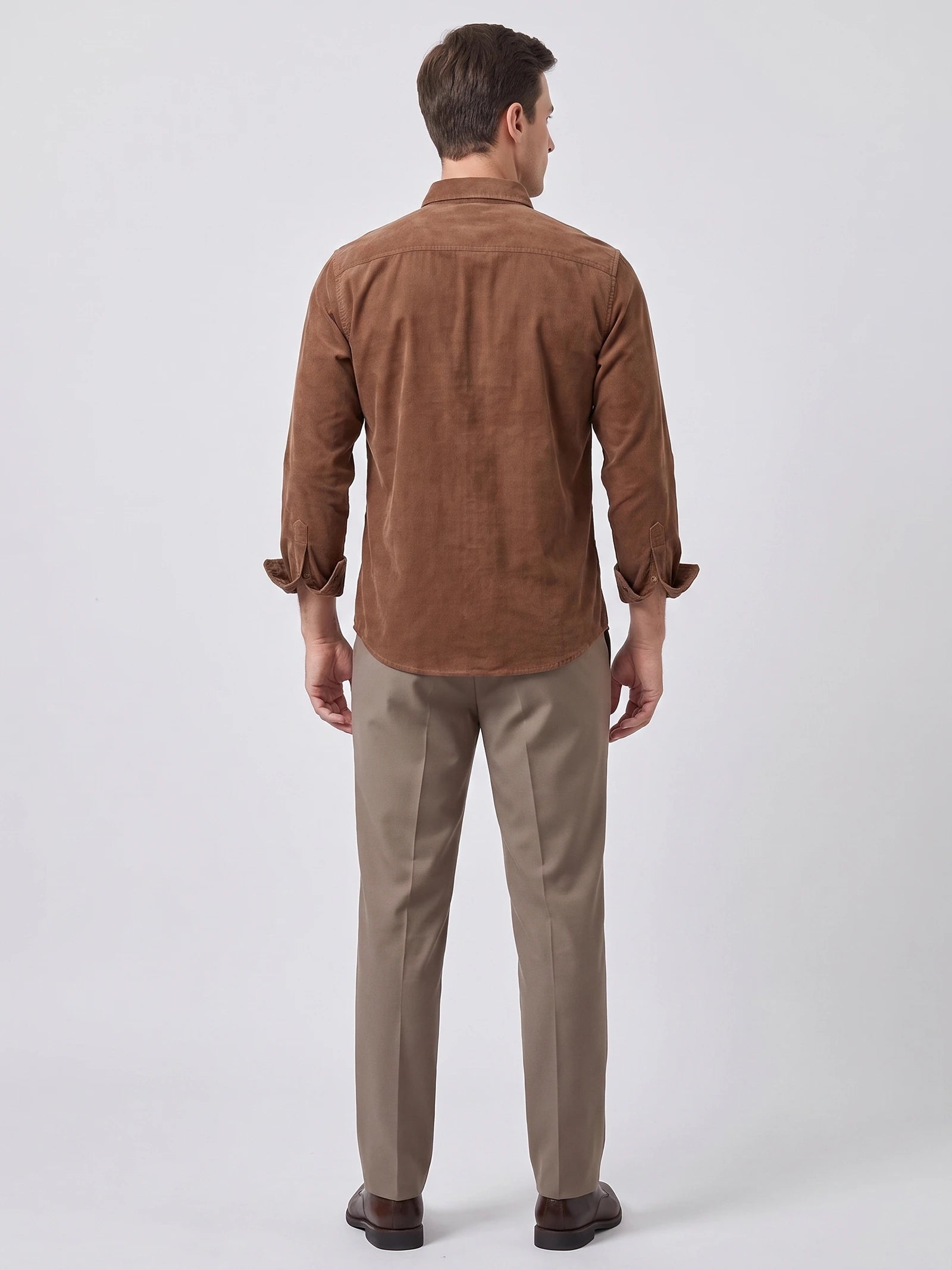 Rear studio view of a model wearing the Brown Twill Tweed Shirt with rolled cuffs and a curved hem.