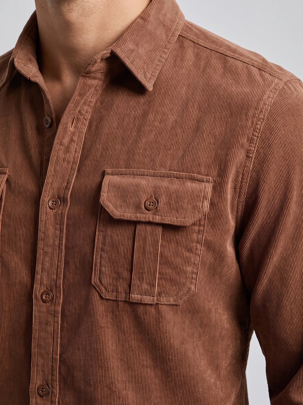 Close-up of a Brown men's Twill Tweed Shirt showing its ribbed cotton texture, pointed collar, button placket, and flap chest pocket.