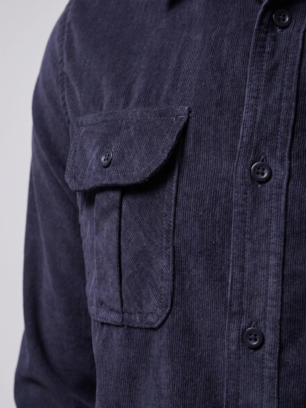 Close-up of the Navy Twill Tweed Shirt showing its ribbed cotton texture, button-front placket, and buttoned chest pocket.