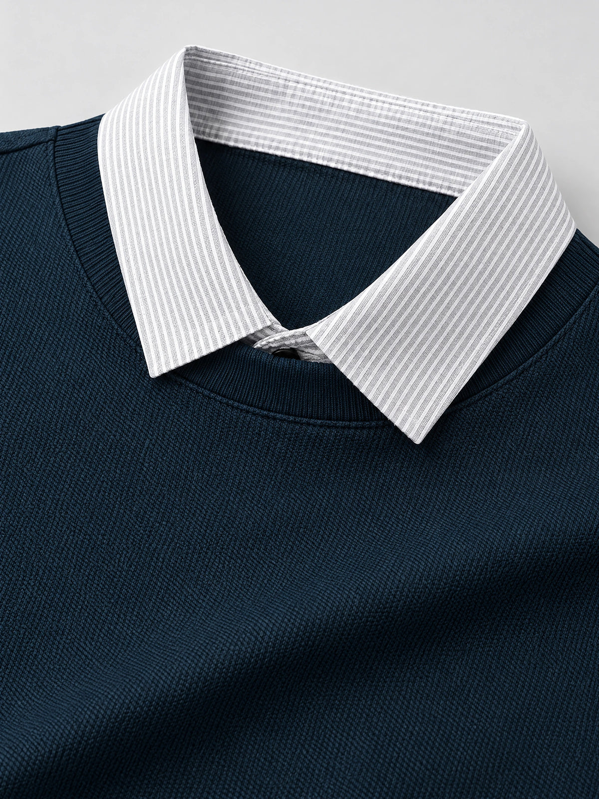 Close-up of the Navy Two Piece Polo Shirt with a striped layered collar and textured knit fabric.