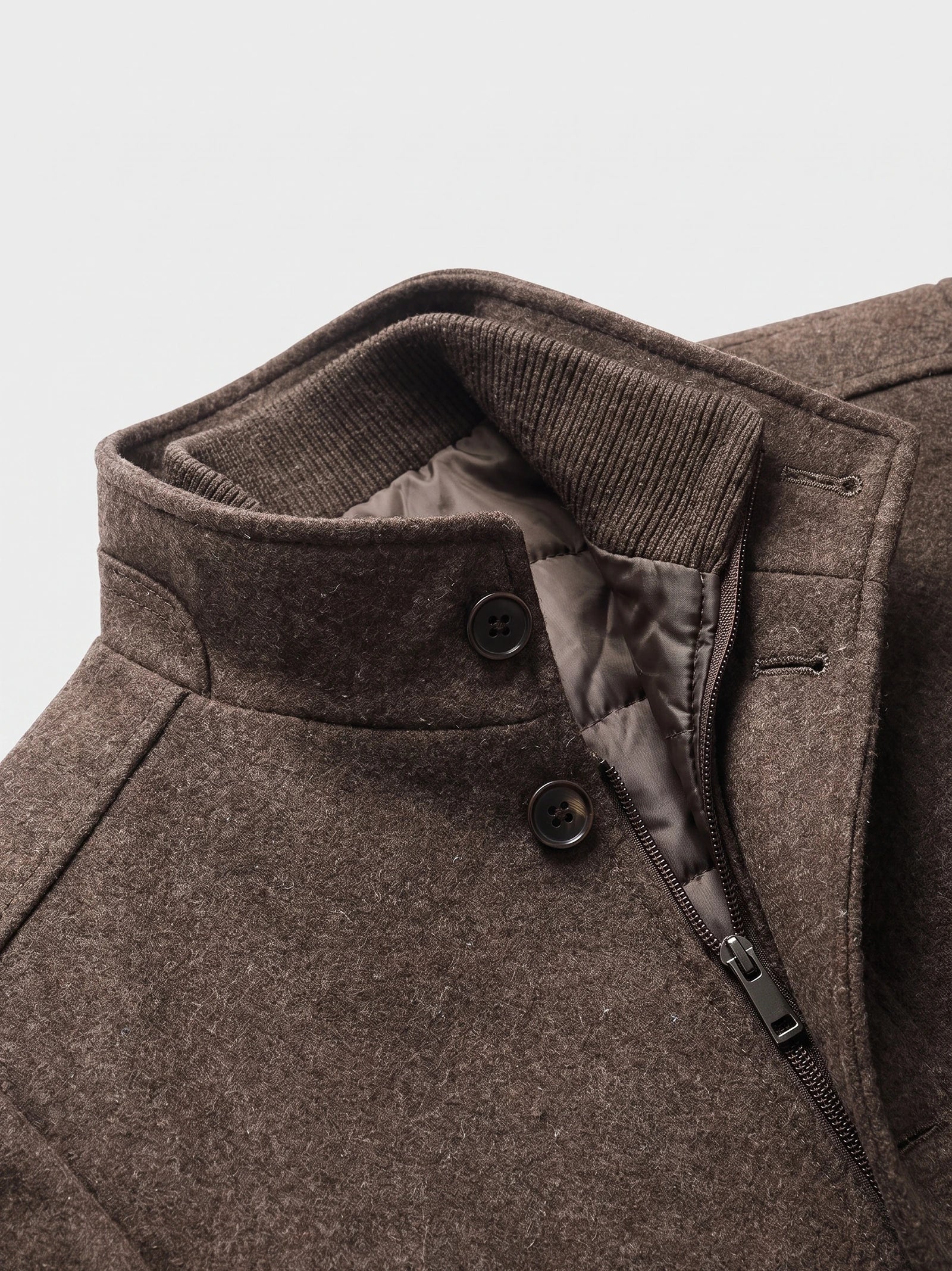 Close-up of the Brown wool overcoat’s stand collar with ribbed inner trim, button closure, and front zipper.