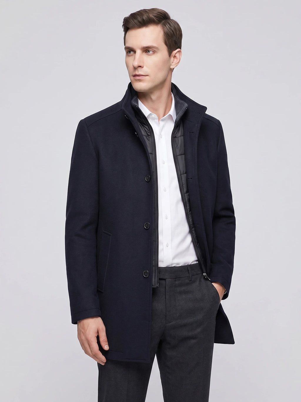 Model wearing a Navy wool overcoat in a front studio view, with a stand collar, button closure, and zip-front inner layer.
