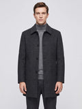 Front studio view of a model wearing a Black wool trench coat with a pointed collar, button front, and angled pockets.