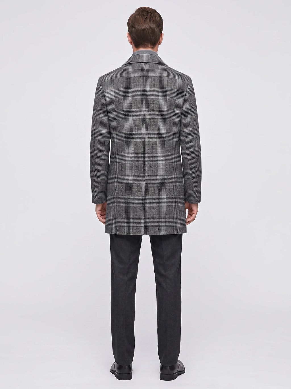 Rear view of a model wearing a Gray Wool Trench Coat with a large checked pattern and straight knee-length hem.