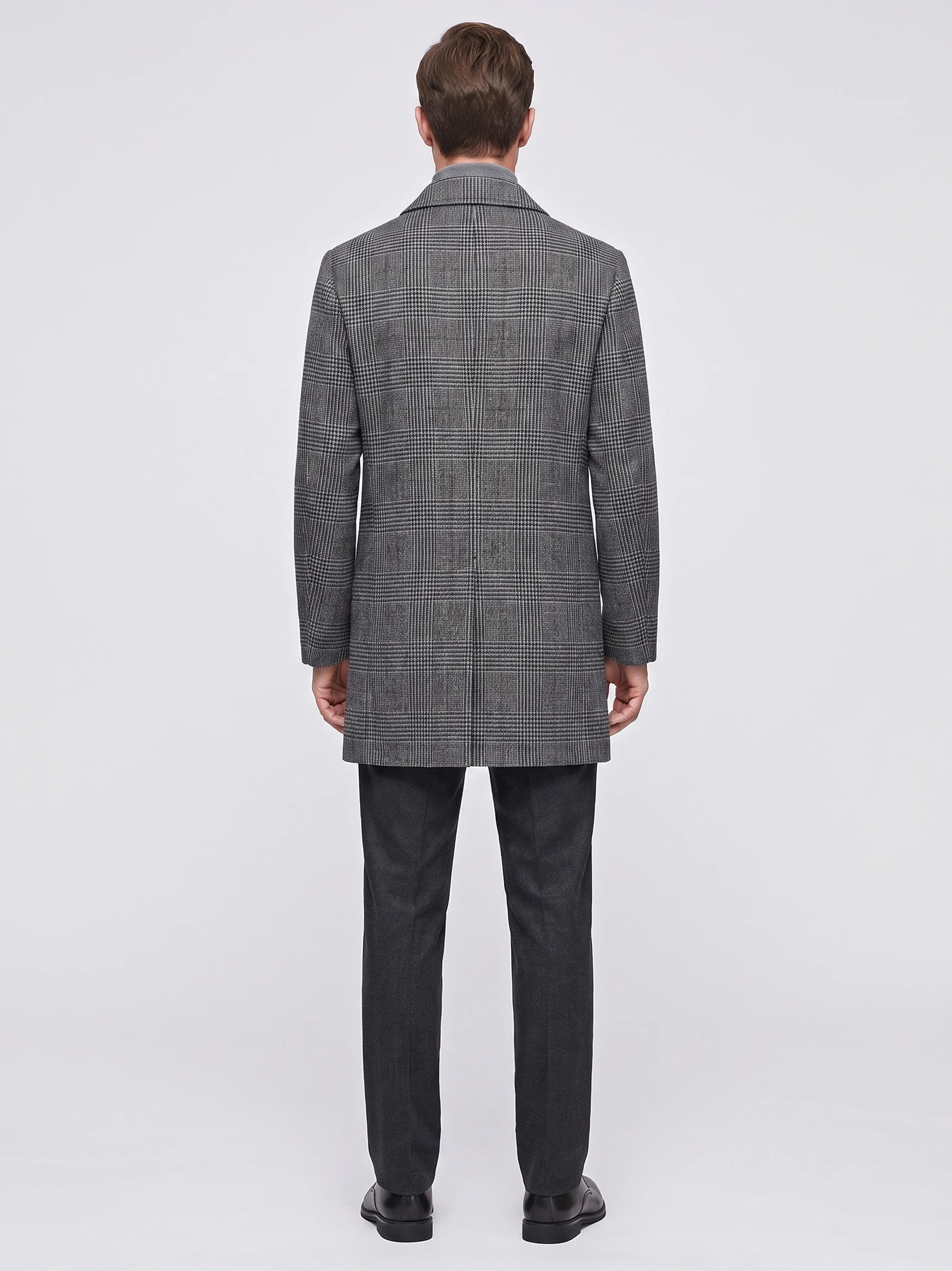 Rear view of a model wearing a Gray Wool Trench Coat with a large checked pattern and straight knee-length hem.