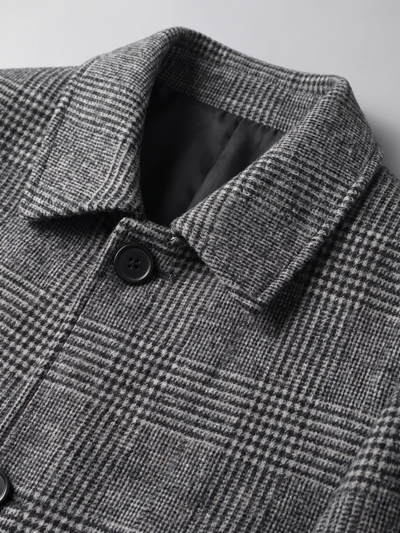 Close-up of the Gray Wool Trench Coat showing its notched collar, plaid texture, lining, and button closure.