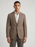 Front studio view of a model wearing a Brown wool tweed blazer with a houndstooth pattern, notch lapels, and flap pockets.