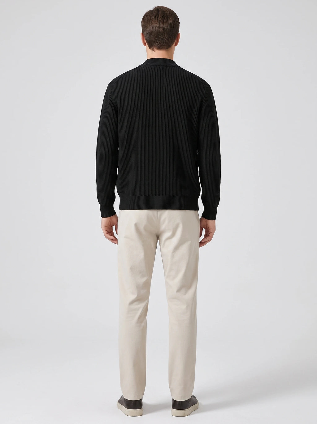 Rear studio view of a model wearing a Black zip up cardigan with vertical ribbed knit texture and a stand collar.