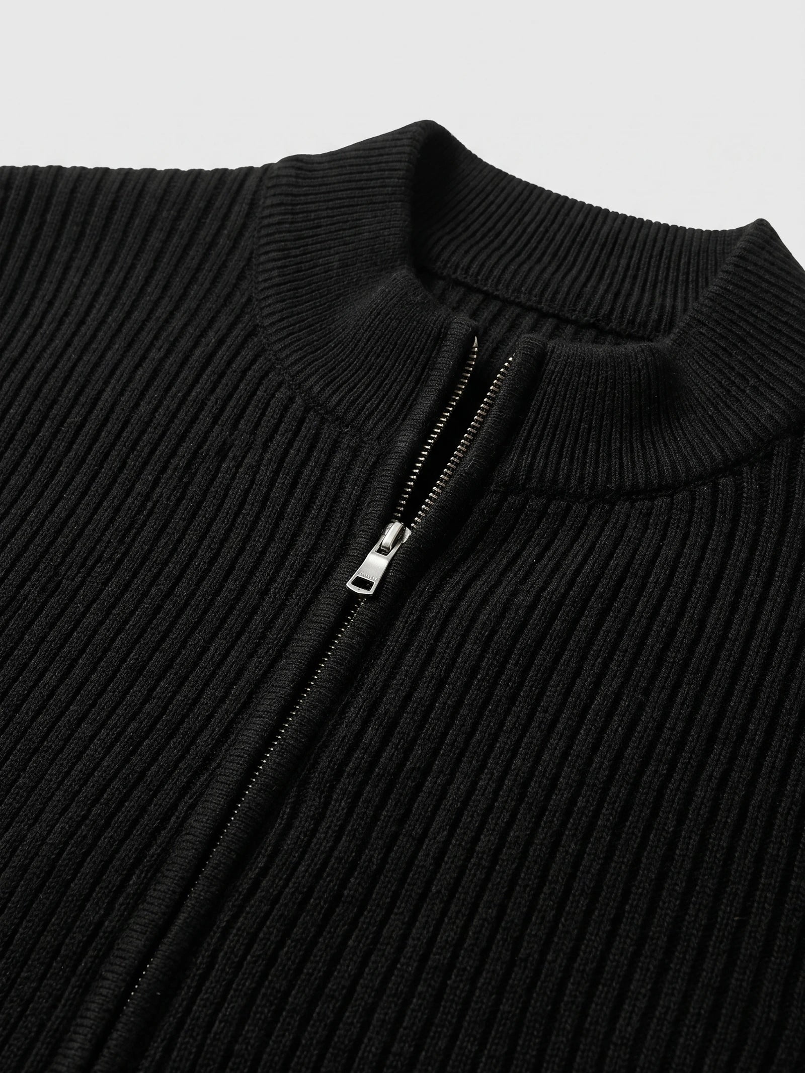 Close-up of the Black men’s zip up cardigan showing the ribbed knit stand collar and front zipper.